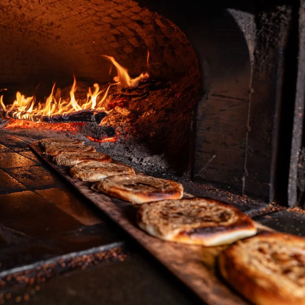 Panes horneándose dentro del horno de leña encendido